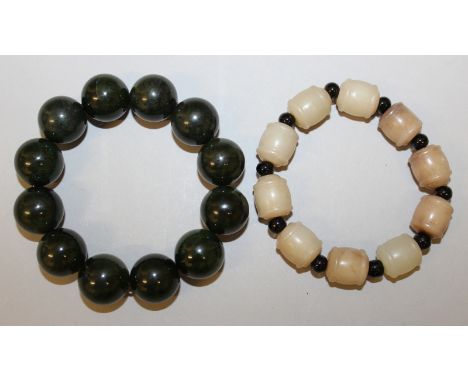 TWO CHINESE JADE-LIKE BRACELETS, one with spherical beads, the other with barrel-form beads. (2)