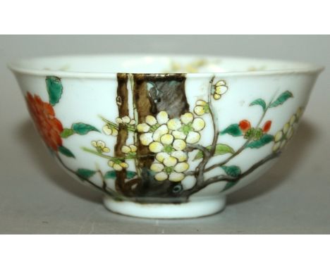 A CHINESE FAMILLE ROSE PORCELAIN BOWL, the sides painted with a blossoming bough and foliage extending over the rim into the 