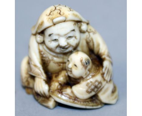 A JAPANESE MEIJI PERIOD IVORY NETSUKE OF DAIKOKU, in the company of a small boy, the details engraved and stained, 1.25in hig