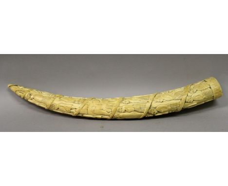 A GOOD QUALITY EARLY 20TH CENTURY CARVED AFRICAN IVORY TUSK, the curving body carved with a spiral procession of figures, 13.