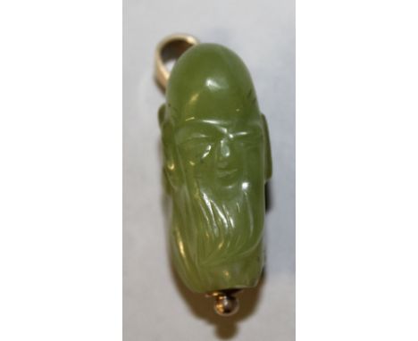 A CHINESE GOLD MOUNTED CELADON JADE PENDANT CARVING OF SHOU LAO, the suspension loop marked '9CT', 1.5in high.