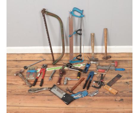 A collection of loose tools including spanners, saws, hammers, etc.  