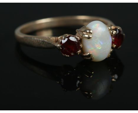 A 9ct Gold, Opal and Garnet three stone ring. Size OÂ½. Total weight: 2.5g.  