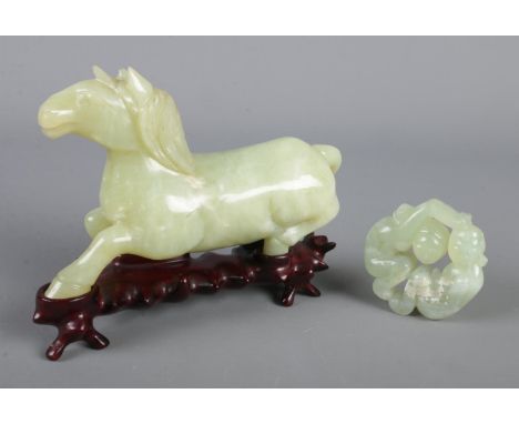 Two pieces of Chinese carved jade. Includes model of a horse on hardwood stand and a bi disc type carving of a man and woman.