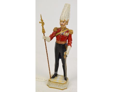 A Sitzendorf porcelain figure of a Gentleman at Arms who formed the bodyguard for the reigning British monarch, carrying a ca