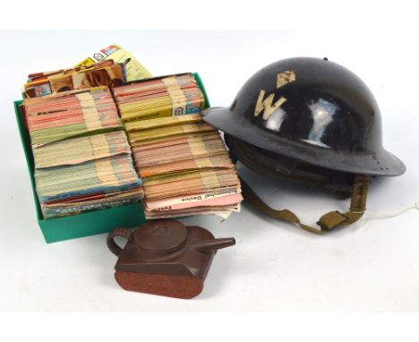 A WWI period warden's helmet with chin strap and liner, a Chinese Yi-Xing teapot modelled as a tank and dated 1985, and an in