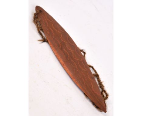 An Australian bullaroarer with incised decoration and twine cord, length 26cm. CONDITION REPORT: The vendor was in Australia 