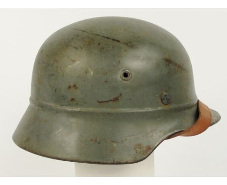 A German WWII M40 civilian issued helmet, painted grey with chin strap and liner.