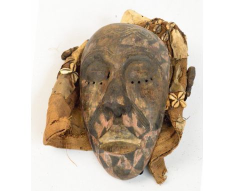 A Dan mask, Liberia/Ivory COast, with traces of polychrome decoration and cowry shell adorned cloth hood, height 28cm.