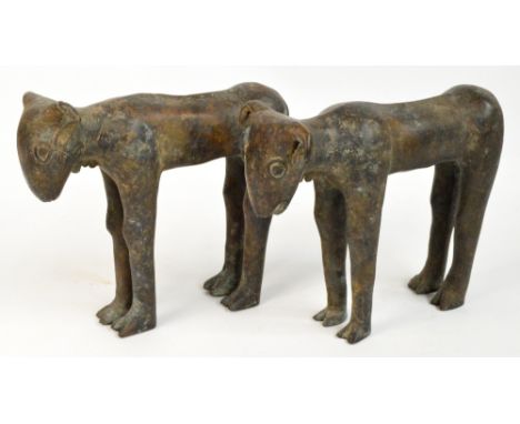 A pair of 16th century Benin bronze models of "grinning" goats modelled four square, length 34cm, height 27cm.