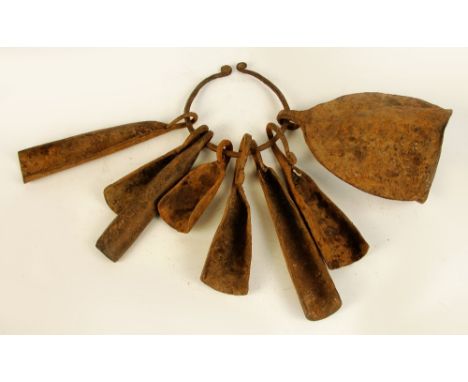 A set of Yoruba iron bells (currency), Nigeria, comprising main ring supporting large hollow bell and seven semi-circular att