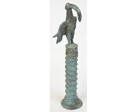A 17th century Benin single staff of office, surmounted with a stylised bird above ring turned central column to spreading ci