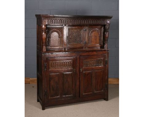 17th century and later oak court cupboard, having carved frieze above a single panelled door, flanked by turned pilasters, wi