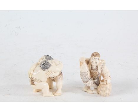 Two Japanese Meiji period carved ivory netsuke, in the form of two sumo's, with red and black detailing, character mark to on