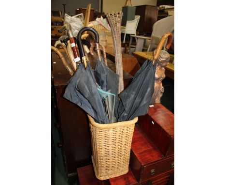 Wicker stick stand with a collection of various walking sticks and umbrellas etc. (qty)