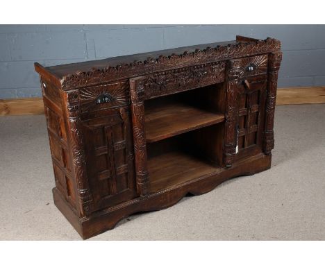 Rajasthani sideboard, the carved frieze above a central open recess with shelf flanked by two drawers and two cupboard doors,