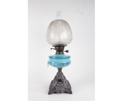 Late Victorian glass and cast iron oil lamp, having etched glass shade above a blue pressed glass reservoir with Art Nouveau 