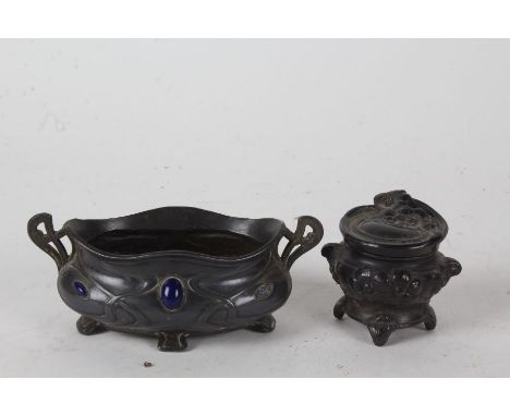 Art Nouveau pewter and enamel twin handled pot, with stylised rim and body, inset with blue enamel ovals (one missing), 13.5c