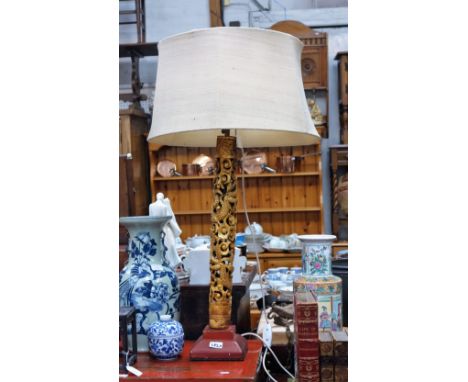 A CHINESE TABLE LAMP, with a carved and gilded column decorated with dragons on a red square foot, 68 cm high (plus all fitti