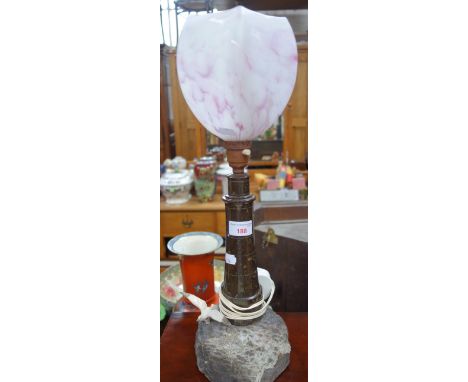 A TURNED SERPENTINE TABLE LAMP in the form of a lighthouse on a rocky base, 31 cm high (plus electric fittings)