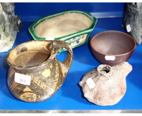 A NAIVE HAND PAINTED POT with a single handle, an ethnic pottery oil lamp and similar ceramics 