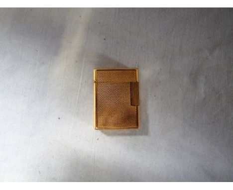 A YELLOW METAL ENGINE TURNED CIGARETTE LIGHTER, the base inscribed 'Dupont Paris made in France'