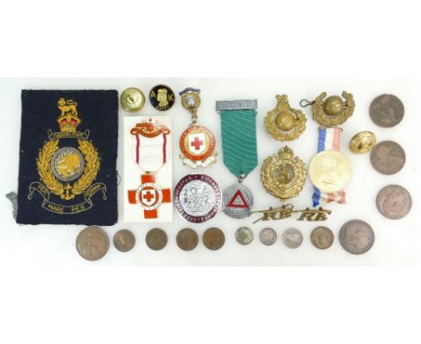 A collection of metal military cap badges, Gibraltar patch, enamelled Red Cross medals, coins etc