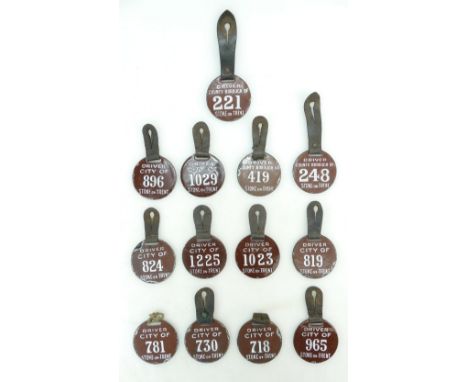 Group of 13 x early 20th century brown and white enamel Taxi / Hackney cab licence discs with leather strap. Disc 6.3cm wide.