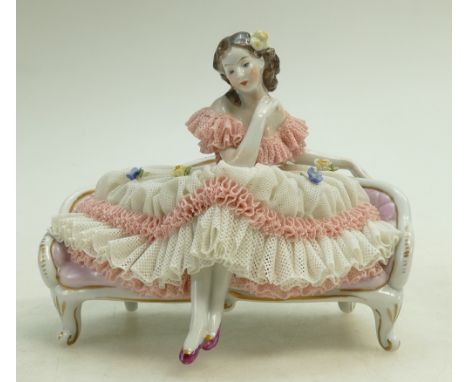 Dresden lace porcelain figure of a lady seated on a sofa, w17 x h15cm (slight loss to bottom edge of lace dress)