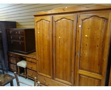 HONEY PINE TRIPLE WARDROBE with drawer base, together with a six drawer dressing table and stool