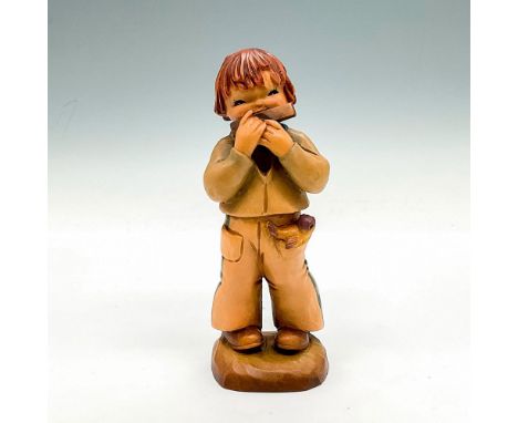 A wood carving of a boy in a sailor pant suit carrying a bird in his pocket. The boy plays the harmonica. Hand painted item. 