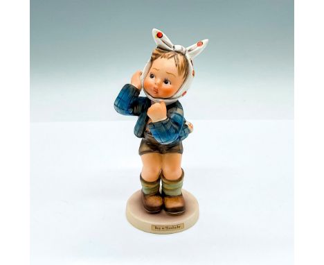 Hand painted and hand decorated figure of a boy in a blue jacket. His head wrapped with in a white cloth with orange dots. Go