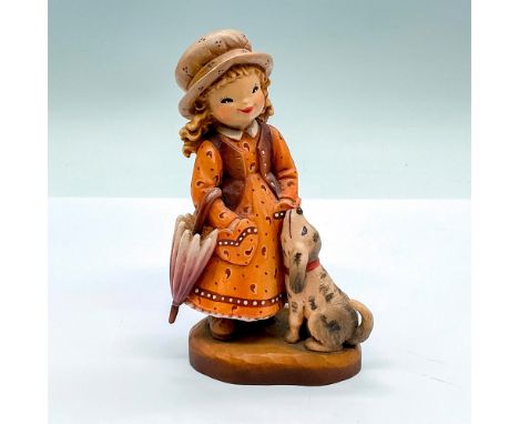 Limited edition. A vintage carved figure of a young girl and a dog, the girl is holding a closed umbrella. Artist carved name