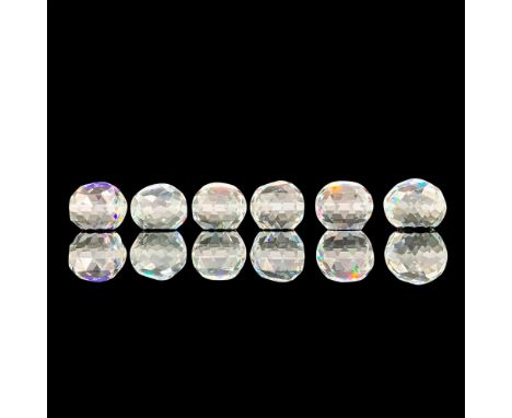 A set of 5 clear round cut crystal paperweights with a Swarovski symbol in the center of each item. The five designs are a bl