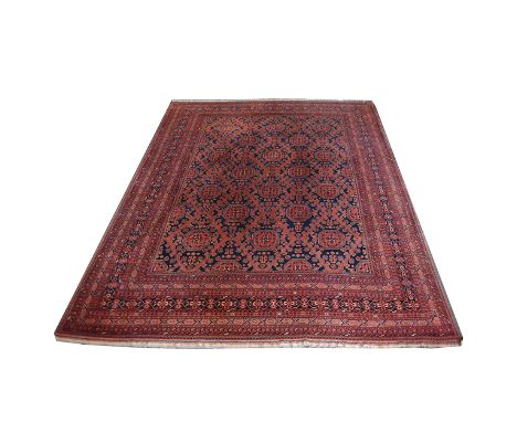 Large Afghan carpet, rows of patterned medallions on a blue field, within multiple borders, 404x305cm.