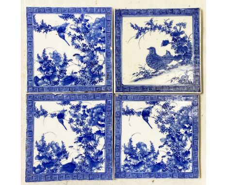 Four Chinese hand painted blue and white tiles, three of the same design with a bird perched amongst flowers enclosed by Gree