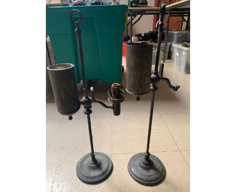 A 19th century oil lamp having cylindrical reservoir and wick either side of a long slender adjustable pedestal, on weighted 
