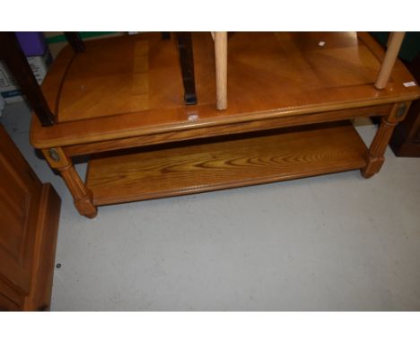 A reproduction coffee table in a light stain, classical style