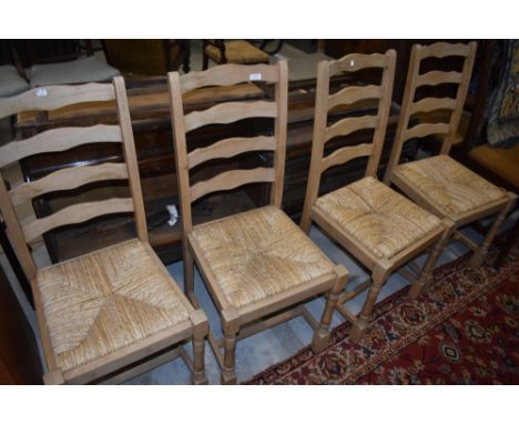 A set of four traditional ladder back rush seated dining chairs