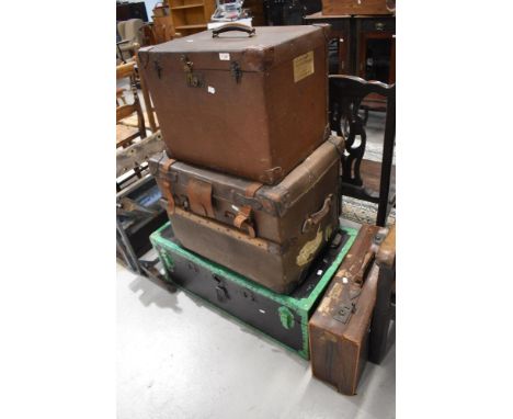 An assortment of vintage luggage, including some with shipping labels