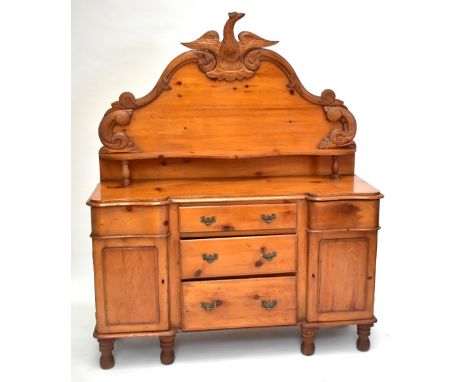 A carved pine sideboard, the single shelf on raised back with eagle crest, on base with five short drawers and two panelled c