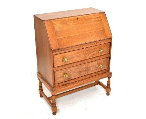 An oak bureau with fall front over two long drawers, on turned and block legs, height 98cm, width 76cm, depth 44cm, together 