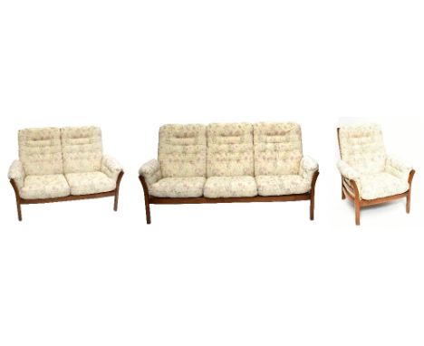 ERCOL; a dark elm three piece Saville suite, comprising a three seater sofa, two seater sofa and armchair.