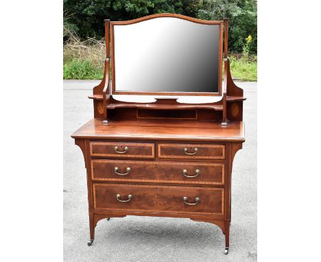 An Edwardian mahogany and satinwood crossbanded dressing table with serpentine bevelled mirror above two short and two long d