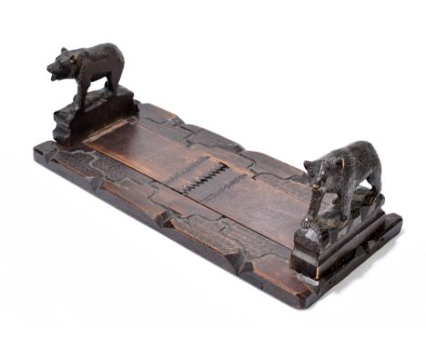 A late 19th century Black Forest carved and stained wood adjustable bookstand, the ends modelled as two bears, length when cl