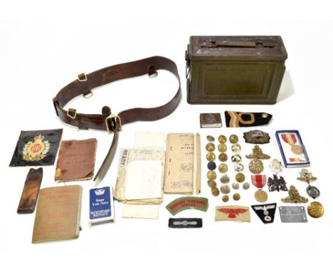 A mixed group of militaria including an ammunition tin, a leather belt, various badges, buttons, etc.