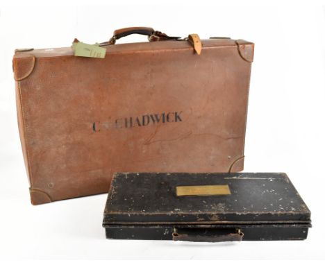 An early 20th century leather suitcase, inscribed 'C. Chadwick' to the top, width 71cm, height 20cm, and a black painted Maso