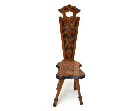 A late Victorian carved oak spinner's chair, the pierced back with foliate detailing above a shaped seat on turned legs, heig