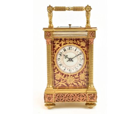 A gilt brass eight day hour repeating carriage clock, the white enamel dial set with Arabic numerals surrounded by pierced gi