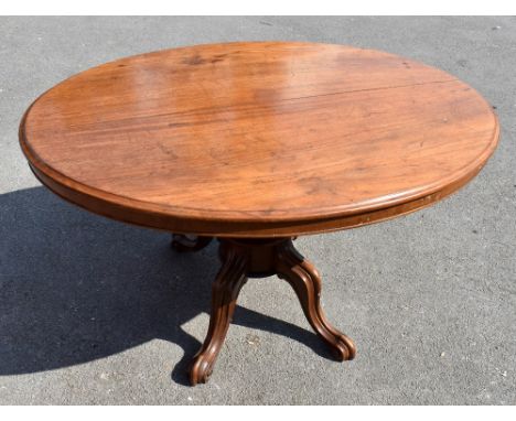 A Victorian mahogany oval loo table, with turned and carved column on four scroll legs, height 71cm, length 134cm, width 102c
